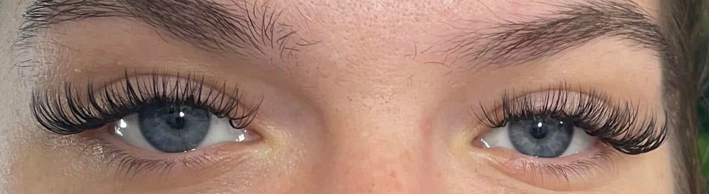 Close-up lash extension work on blue eyes